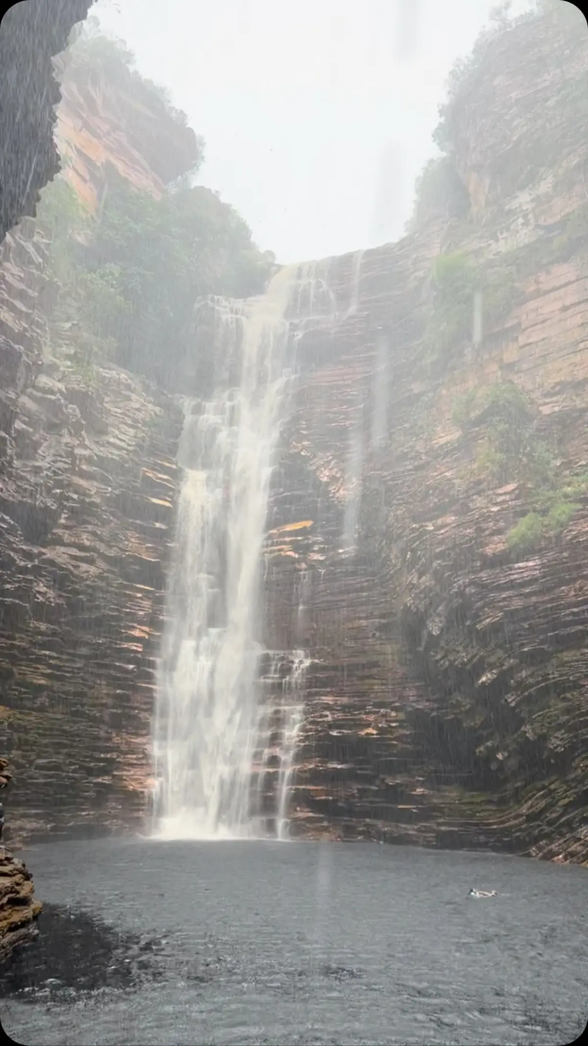 Cachoeira do Buracão vista de dentro do cânion estreito, com a água escura e espumosa